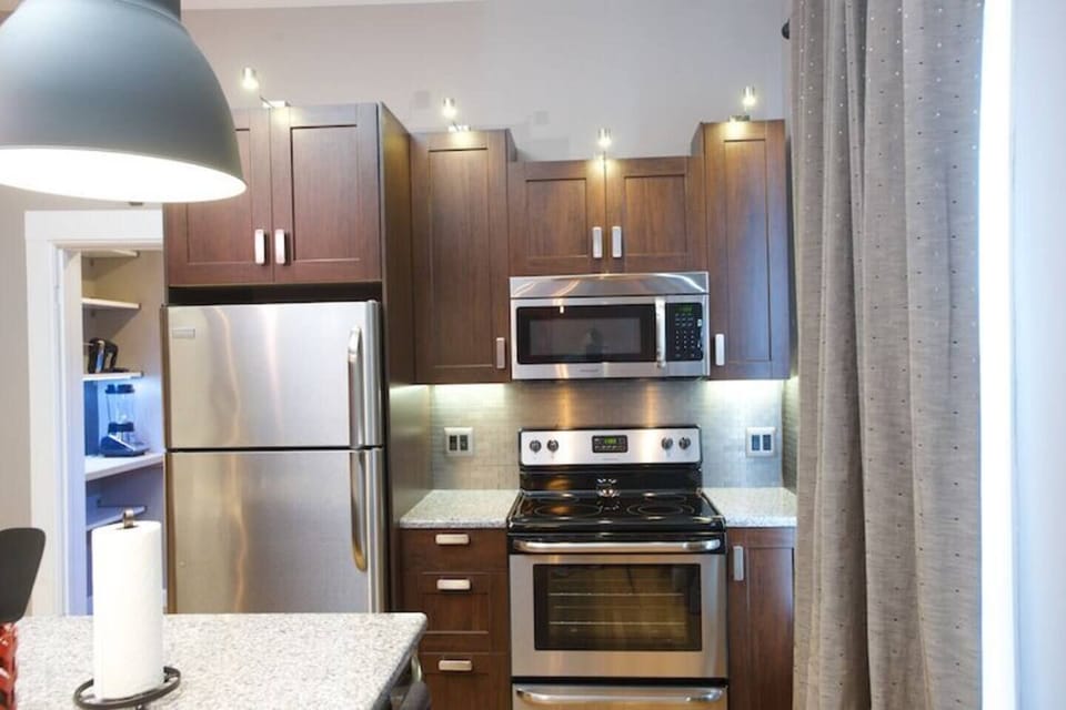Microwave/vent above the electric range with stainless steel refrigerator with ice maker