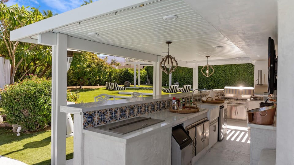 Outdoor kitchen with fridge, ice maker, grill, and pizza oven