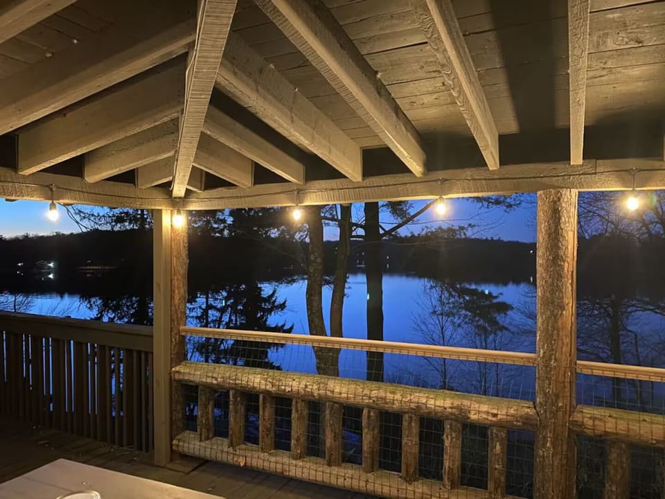 Cozy covered deck with string lights and serene lakefront views