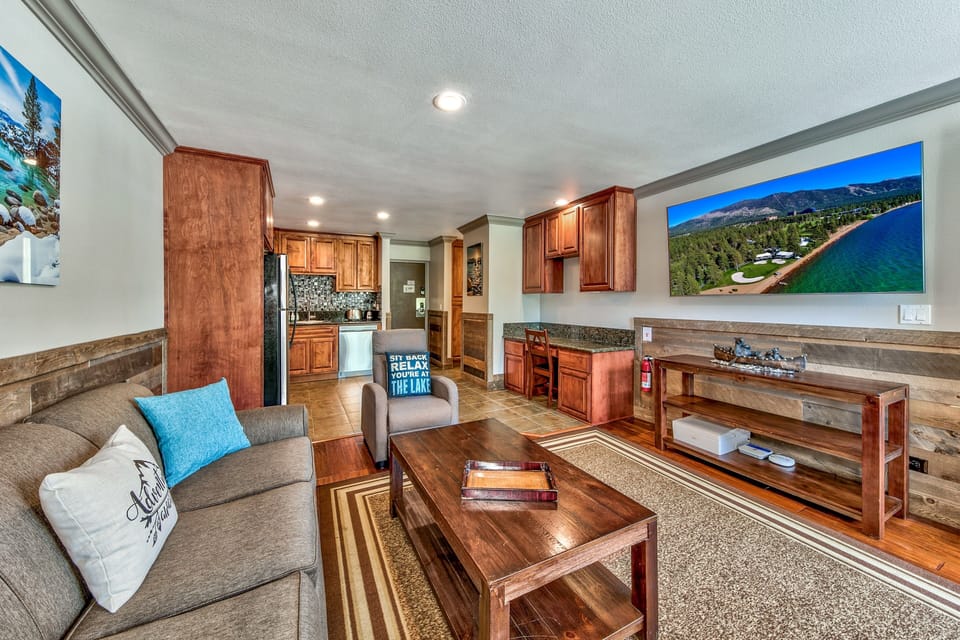 Relax in your elegant living space featuring rich wood furnishings, granite countertops, and a fully equipped kitchen for your mountain getaway comfort.