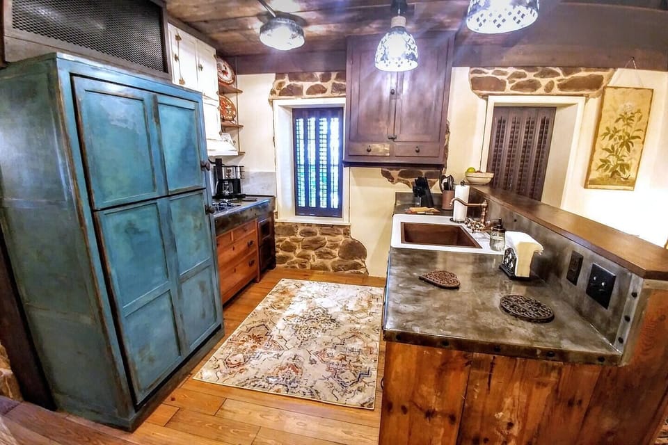 Main level kitchen in the historic Stenhuset features full-size refrigerator, dishwasher, cooktop and convection microwave