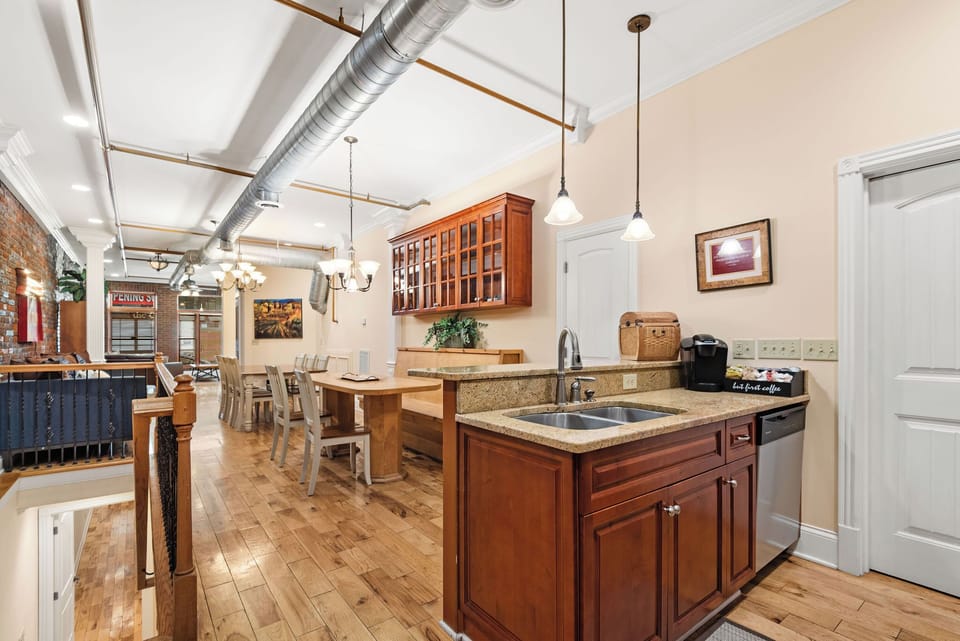 - Open kitchen and dining area with pendant lighting and bar seating   - Hardwood floors and bright cabinetry enhance this inviting space   - Smooth flow between rooms makes gathering and hosting simple