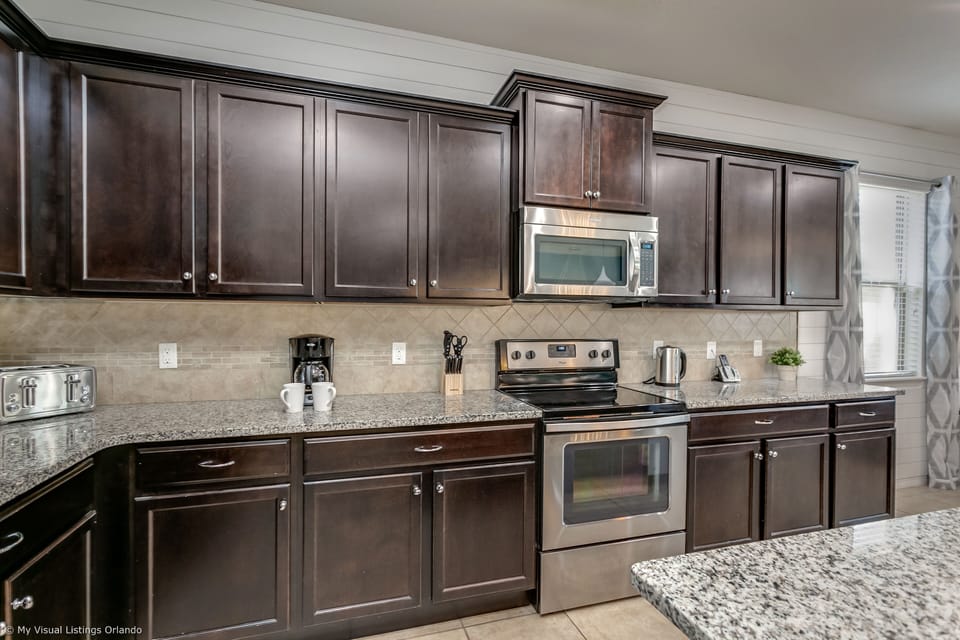View 3 of modern style kitchen including microwave, stove, and double door refrigerator