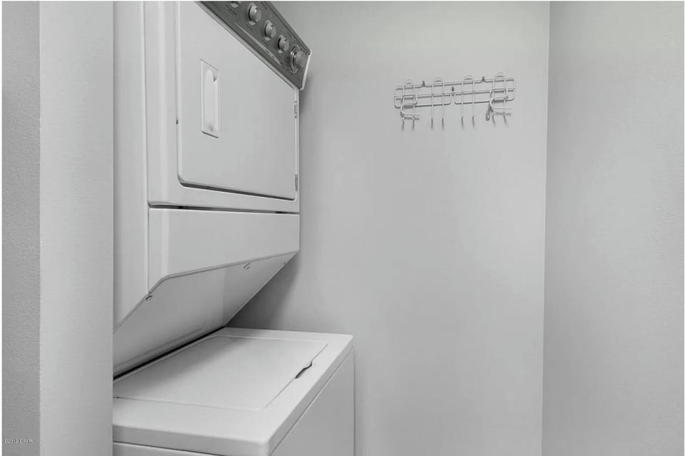 Your dedicated laundry space keeps you organized with a stacked washer and dryer, plus convenient hanging rack for delicate items.