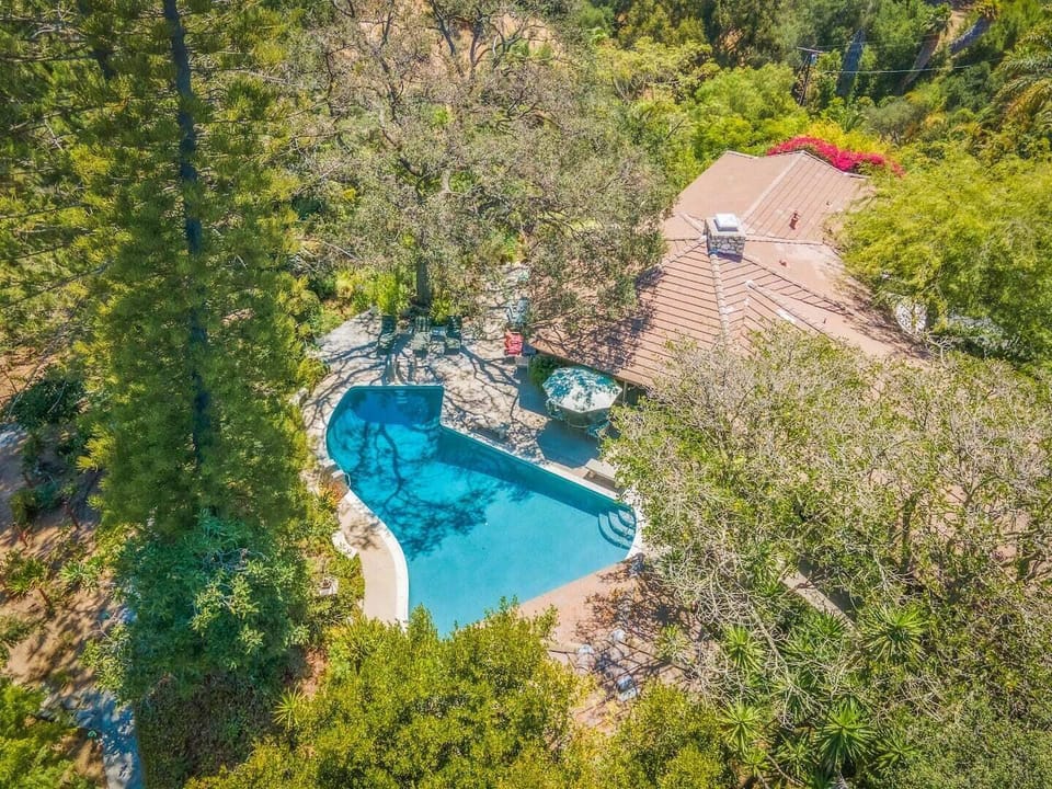 The piano shaped pool is perfect complement to the grandeur vibe of the house. From the pool, beautiful mountain views to the north and private gardens down the steps.