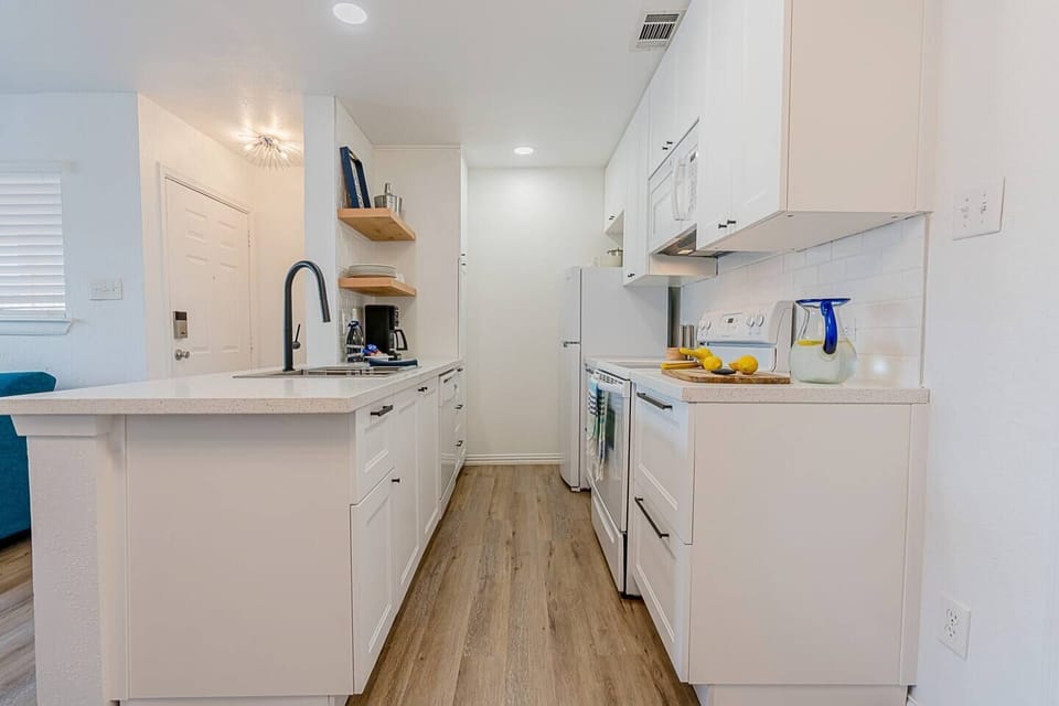 Bright, fresh and new galley style kitchen is well stocked with utensils