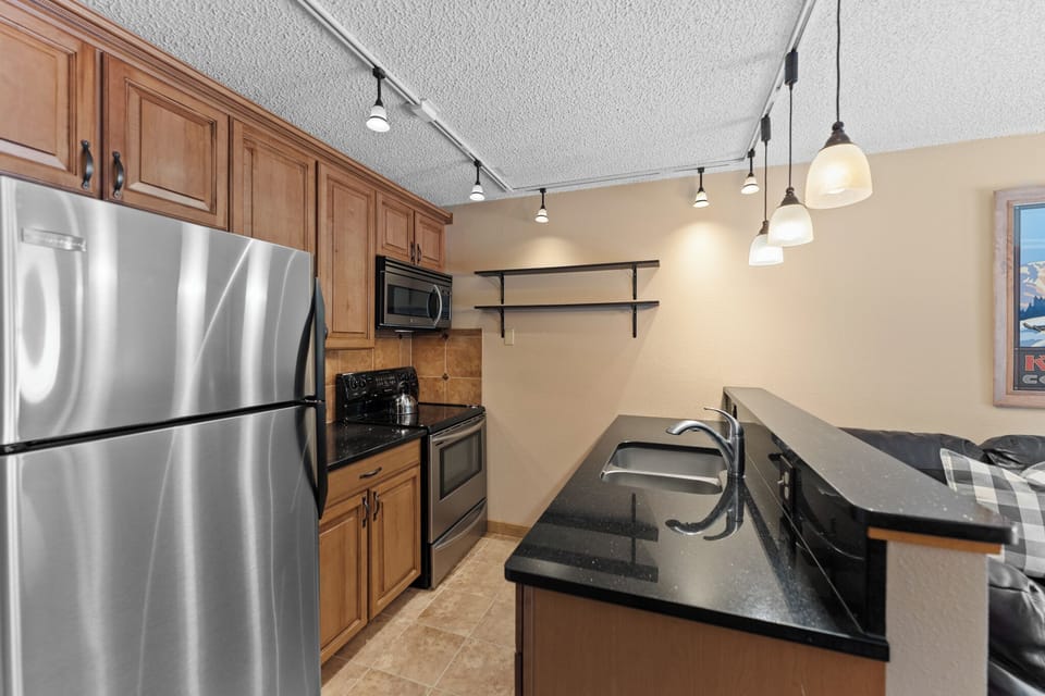 Your fully equipped kitchen features stainless steel appliances, granite countertops, and modern pendant lighting for all your culinary adventures.