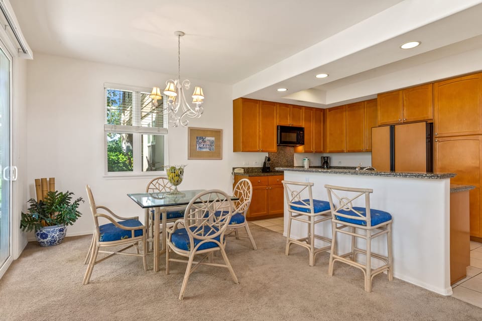 Picture yourself preparing meals in this fully equipped kitchen, gathering at the breakfast bar, or enjoying relaxed dining beneath the elegant chandelier as natural light streams in.
