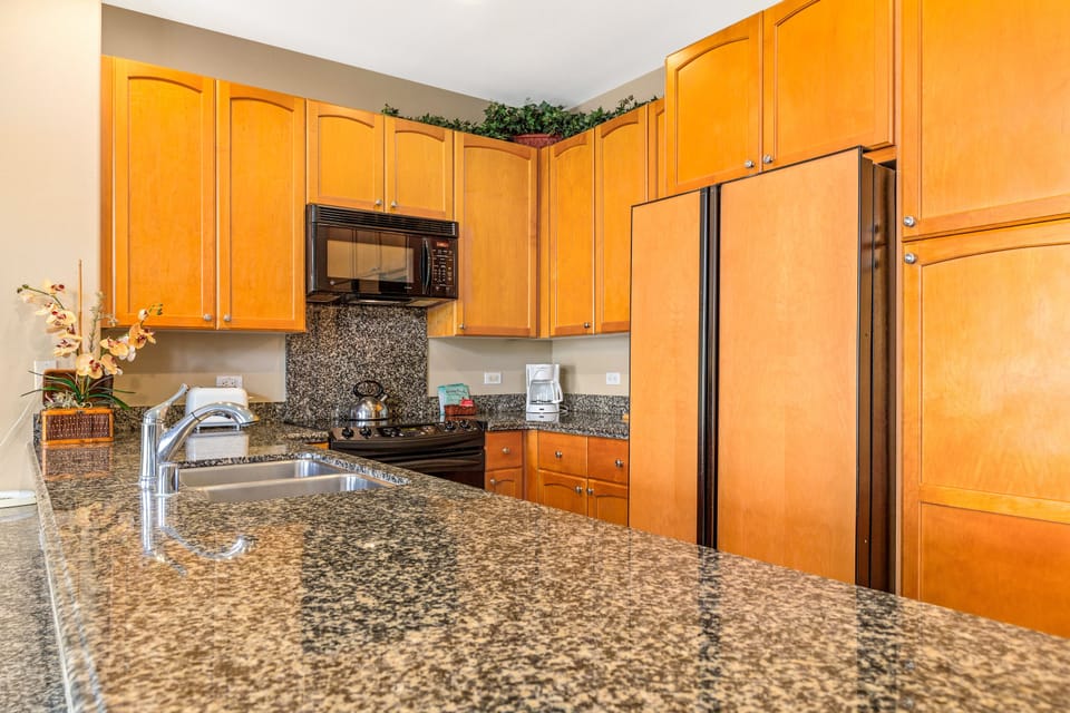 Your fully-equipped kitchen features warm wood cabinetry, gleaming granite countertops, and modern appliances—everything you need to whip up delicious homemade meals during your stay.