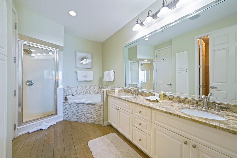 Bright primary bathroom with double vanity and spa-style tub