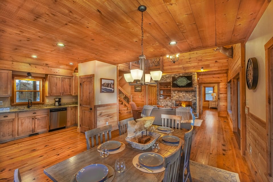 Charming dining room in High Hopes, featuring a large wooden table set against a backdrop of stunning mountain views