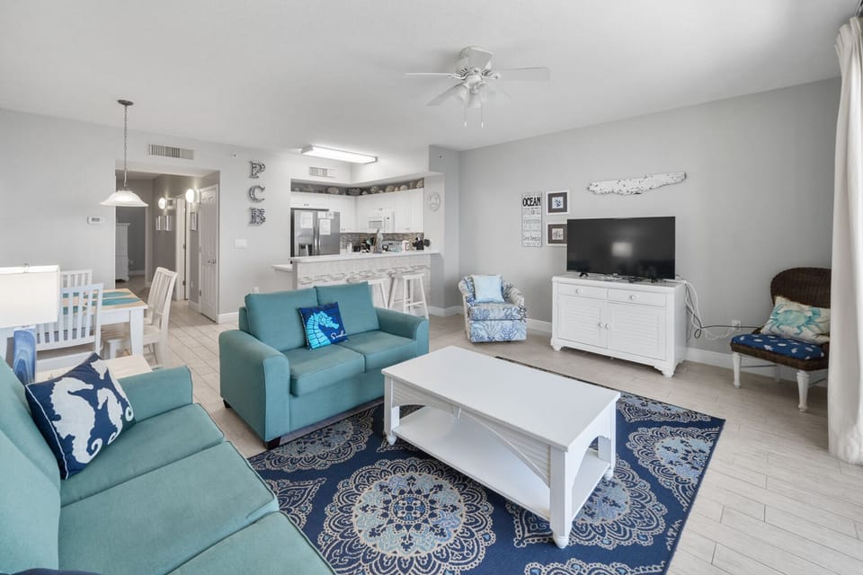 Sink into the plush turquoise sectional while coastal breezes from the ceiling fan keep you cool in this bright, open living space.
