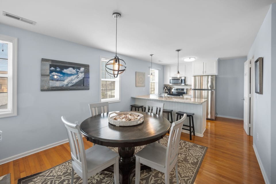 Dining area with 4 chairs and 4 additional bar seats in kitchen.