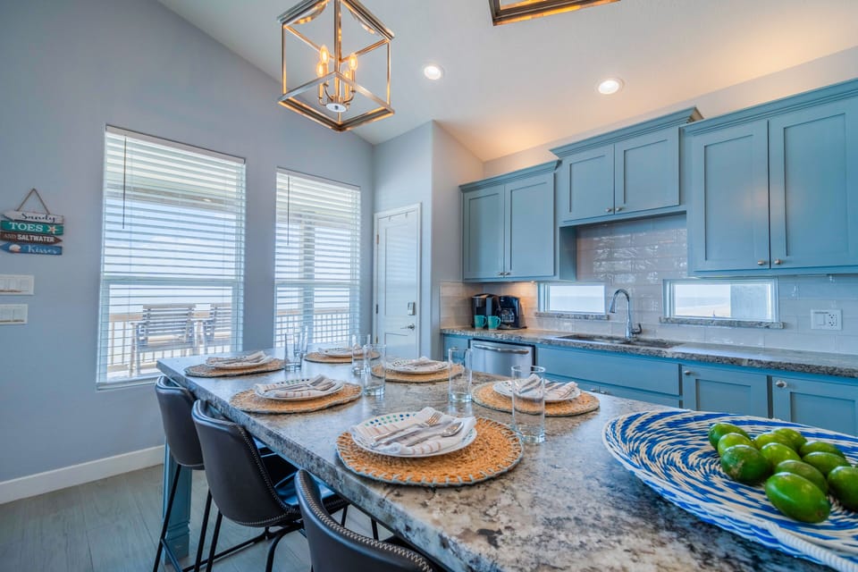 Whip up beachside feasts in a fully equipped kitchen featuring a massive granite island with seating for seven.