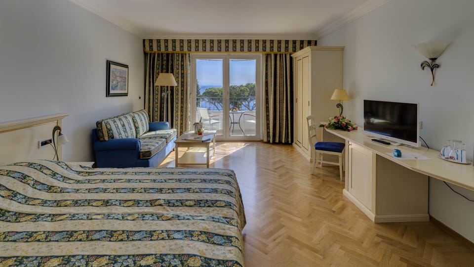 Deluxe double room with sea view | Living area | Flat-screen TV, books, stereo