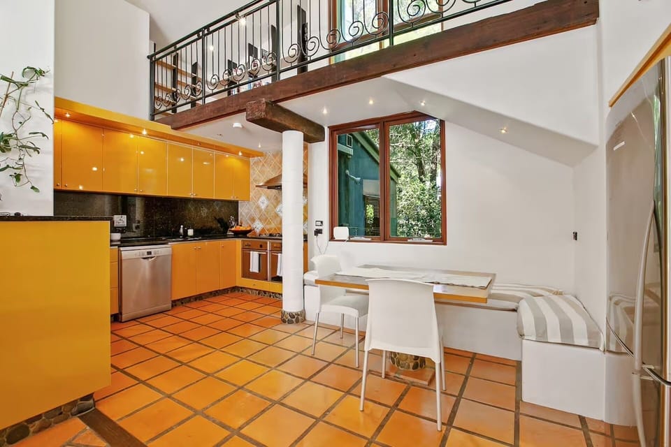 Large kitchen with dual ovens, Nespresso coffee setup and breakfast bar seating.