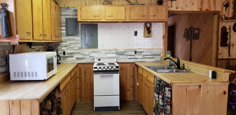 Kitchen with a stove/oven, microwave, coffee maker, double sink