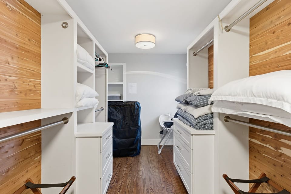 Primary walk-in closet. w/ 2 brand new hotel-style rollaway beds, high chair and pack and play stored here. 