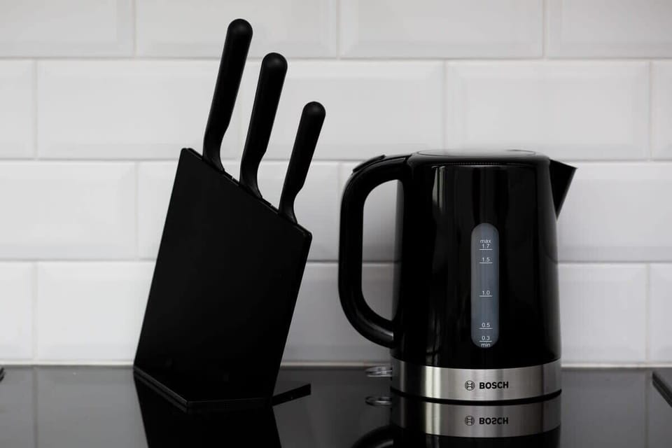 Close-up of knife set and electric kettle in black.  