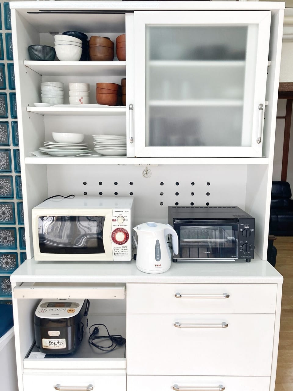 Spacious kitchen with kitchen appliances, such as microwave, rice cooker, kettle, toaster.