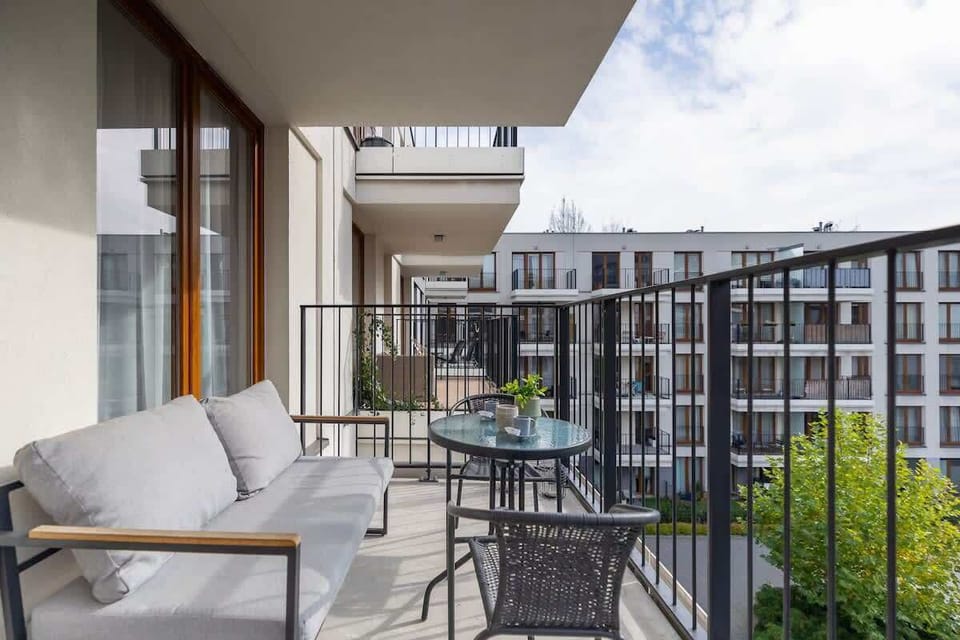 Another angle of the balcony, featuring a cozy lounge setup and a scenic residential view.
