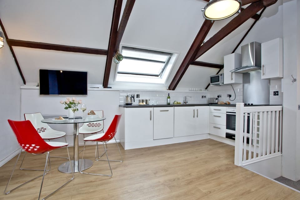 The kitchen area, oven and hob with dining table - Anchor Cottage