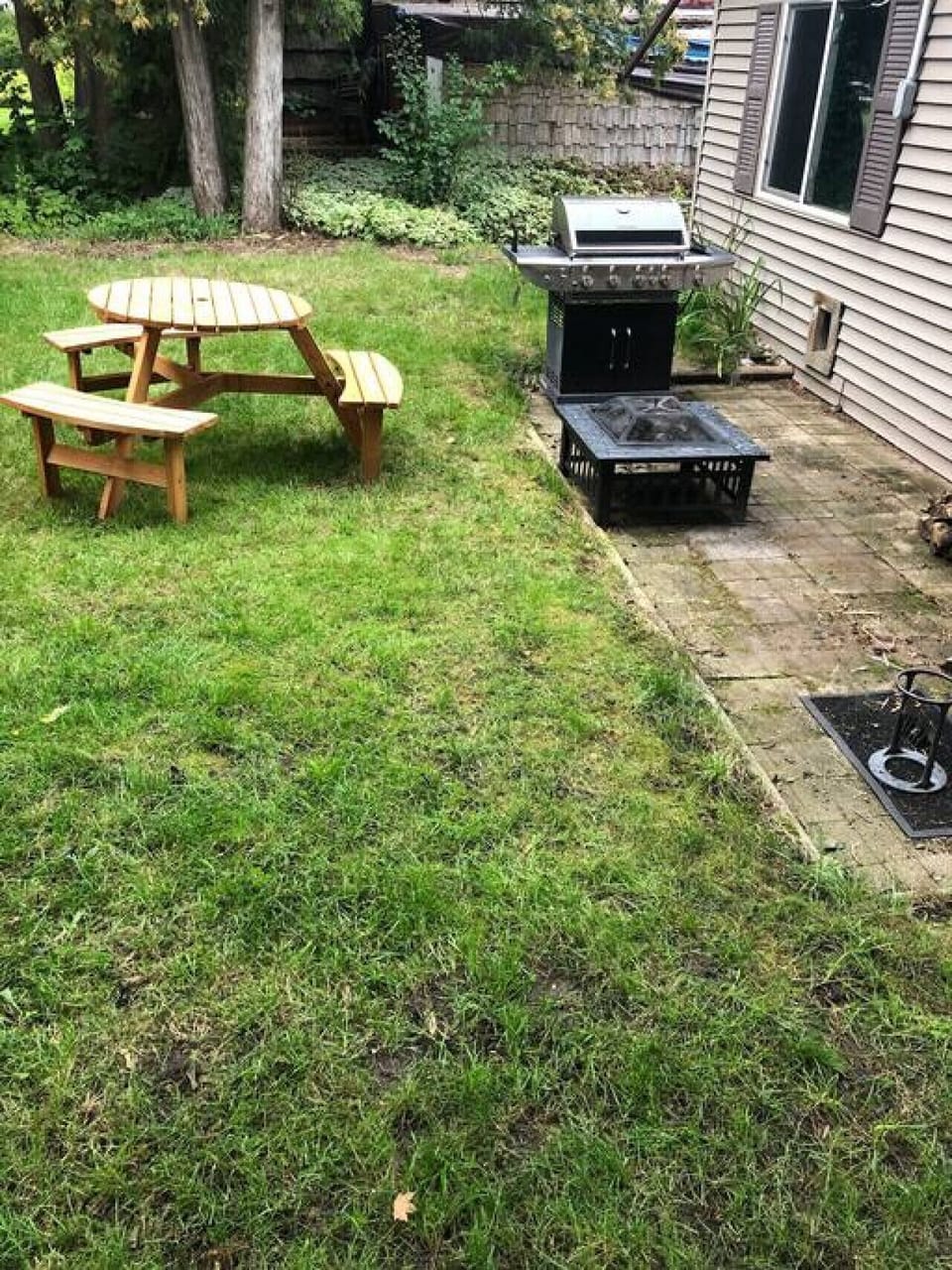 Grill, fire pit and picnic table in the backyard.