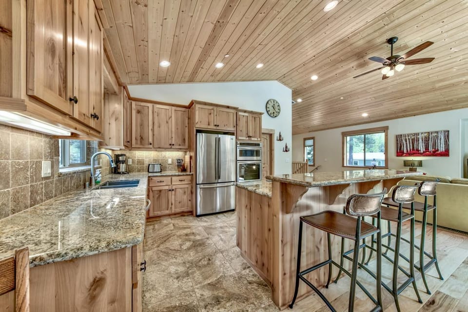 Your rustic yet modern kitchen features warm wood cabinets, granite countertops, and a spacious island perfect for cooking together.
