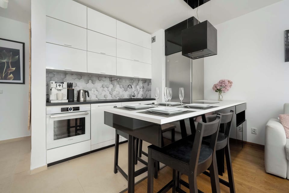 A modern kitchenette with high-quality appliances and a dining area featuring a stylish table and chairs, perfect for meals and gatherings.