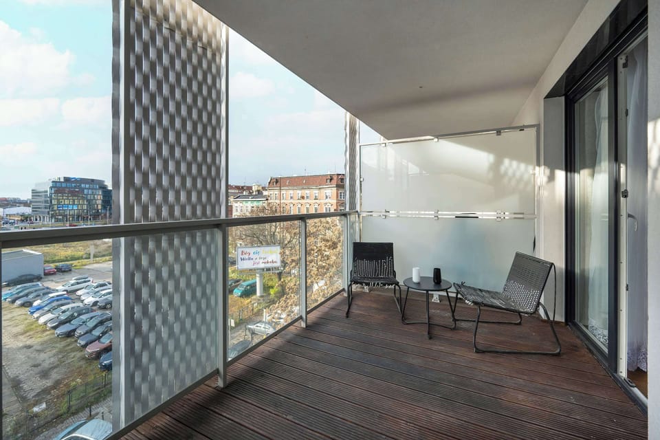 A dining setup with a table and chairs positioned near large glass doors that open to a balcony or patio area.