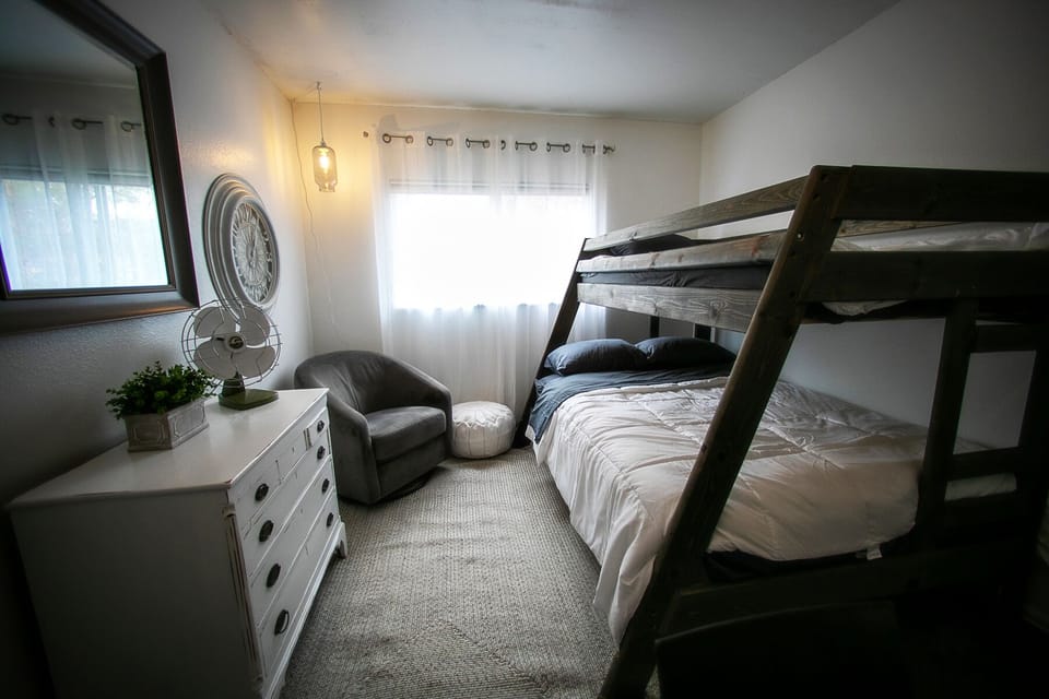 Bedroom with full + single (new) mattresses. Glider/rocker. Vintage dresser. 