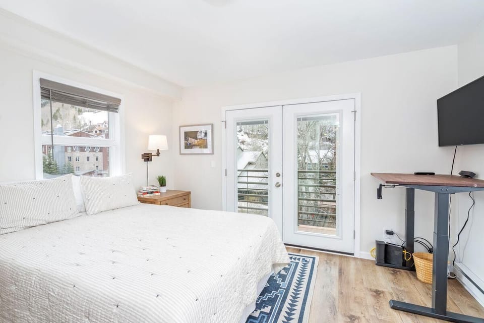 The queen bedroom has beautiful views in three directions, features a flat screen TV, and opens to a private balcony with ski area views.