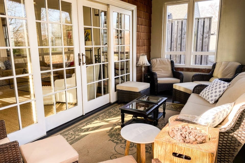 Relax on the screened-in back porch with cozy  furniture and a gas fireplace.