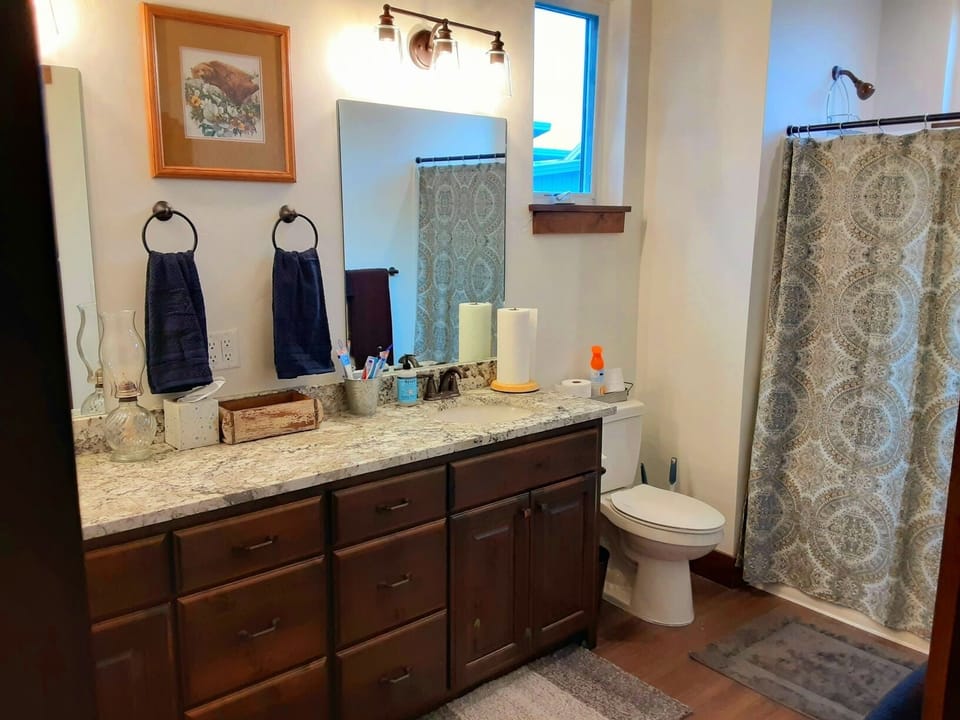 Large upstairs bathroom with double vanity with shower and tub combination.