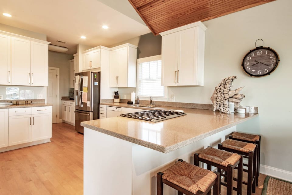 This fully equipped kitchen has granite countertops, white cabinets and an abundance of counterspace.