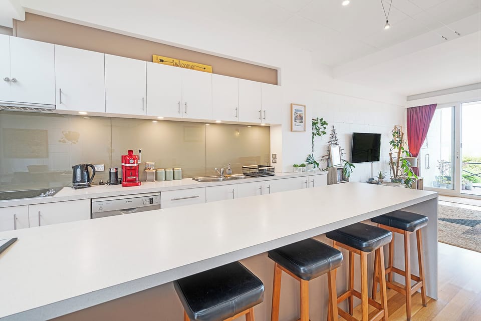 Gather around the kitchen island for shared meals and conversation, a relaxed dining area that brings everyone together at the heart of the home.