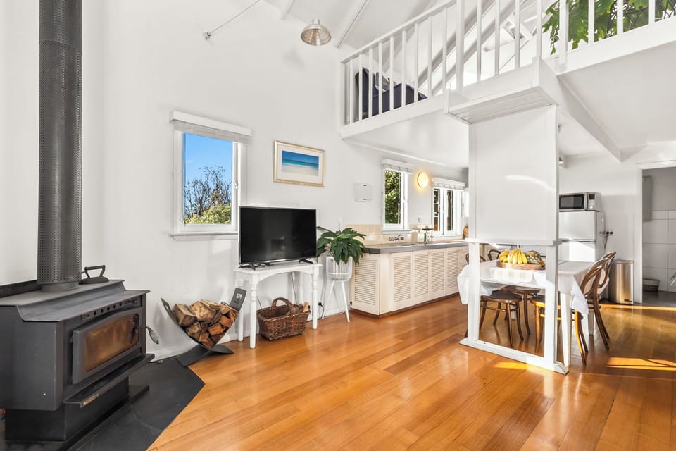 Curl up beside the crackling wood-burning fireplace, where warm timber floors and the home's airy loft design create the perfect setting for cosy evenings after a day exploring Hobart.