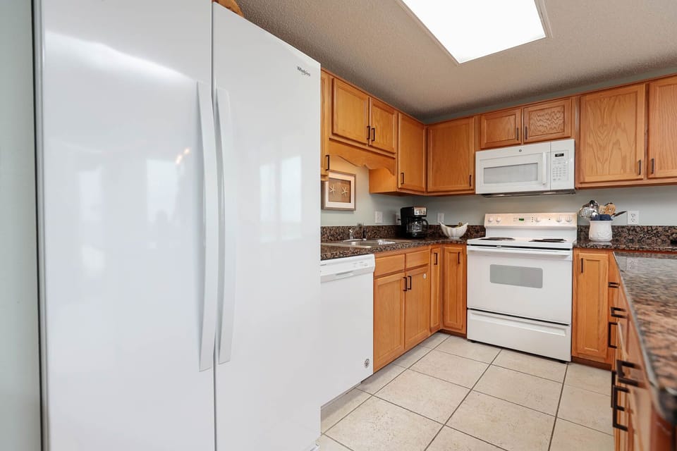 Bright wood cabinetry complements the spacious kitchen, featuring a convenient breakfast bar