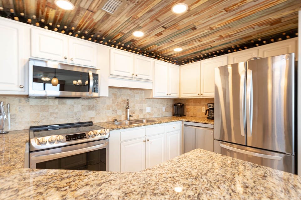 Cook and gather in this modern kitchen featuring granite countertops and stainless appliances for a delightful experience