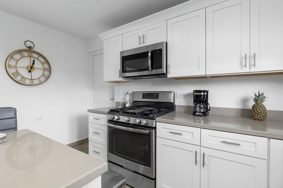 Well-equipped kitchen, featuring a microwave, stove, and drip coffee maker.