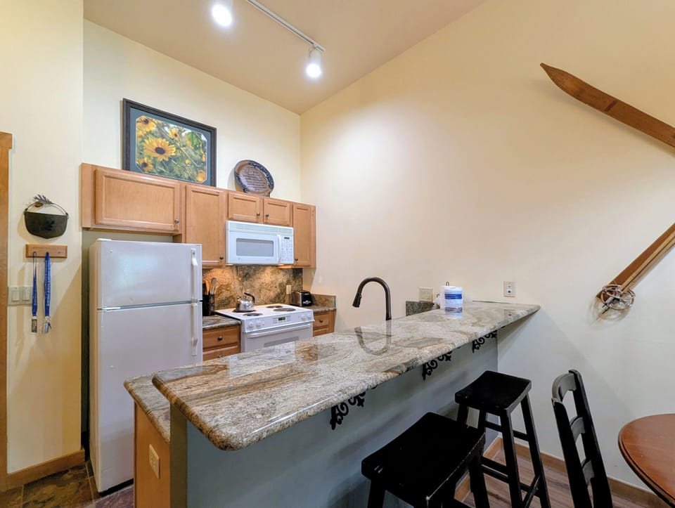 Your fully equipped kitchen features granite counters, modern appliances, and a breakfast bar where you can savor morning coffee or prepare a home-cooked meal in comfort.