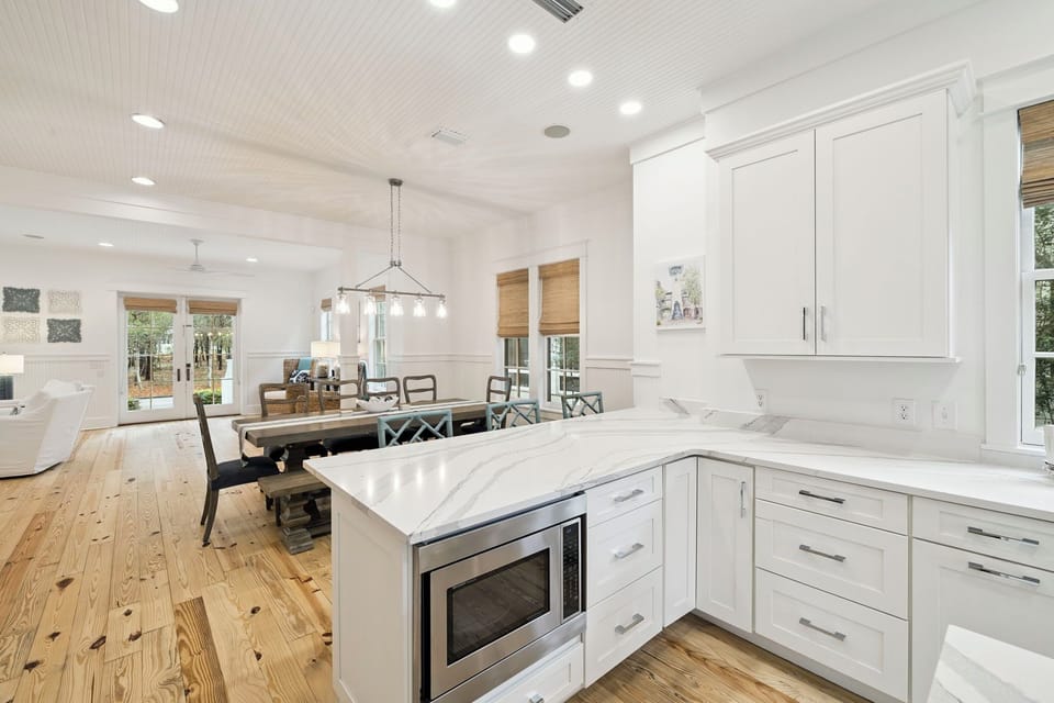 Your dream kitchen awaits with gleaming marble counters, chef-grade appliances, and warm wood floors flowing into the bright dining space.