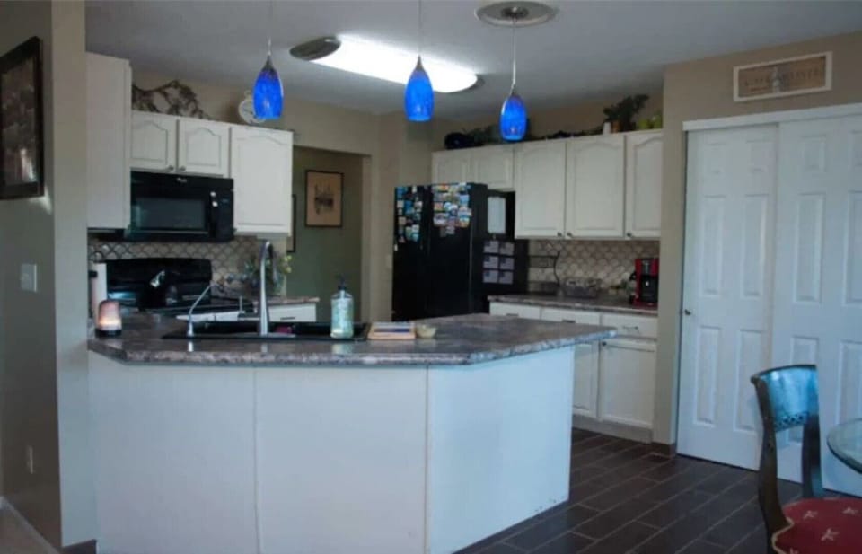 Kitchen with furnished with modern appliances, silverware, and spices