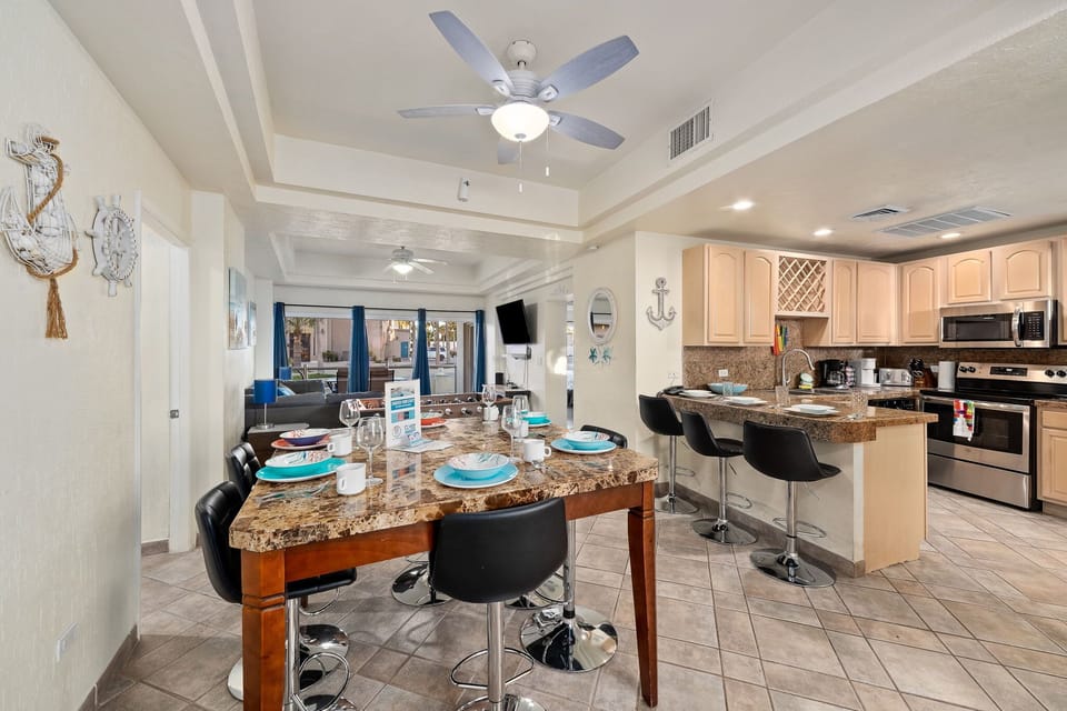 Open-concept layout with dining area, granite breakfast bar, and cozy living room perfect for group gatherings or family meals.