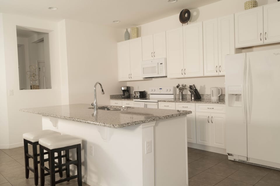 Open kitchen fully stocked with dishes, glasses, cookware, and utensils.