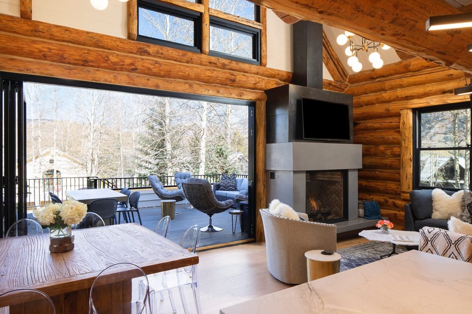 View from kitchen of outdoor dining table and lounge swivel chairs