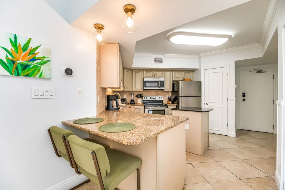 Fully equipped kitchen with granite island and breakfast bar at White Caps beachfront condo