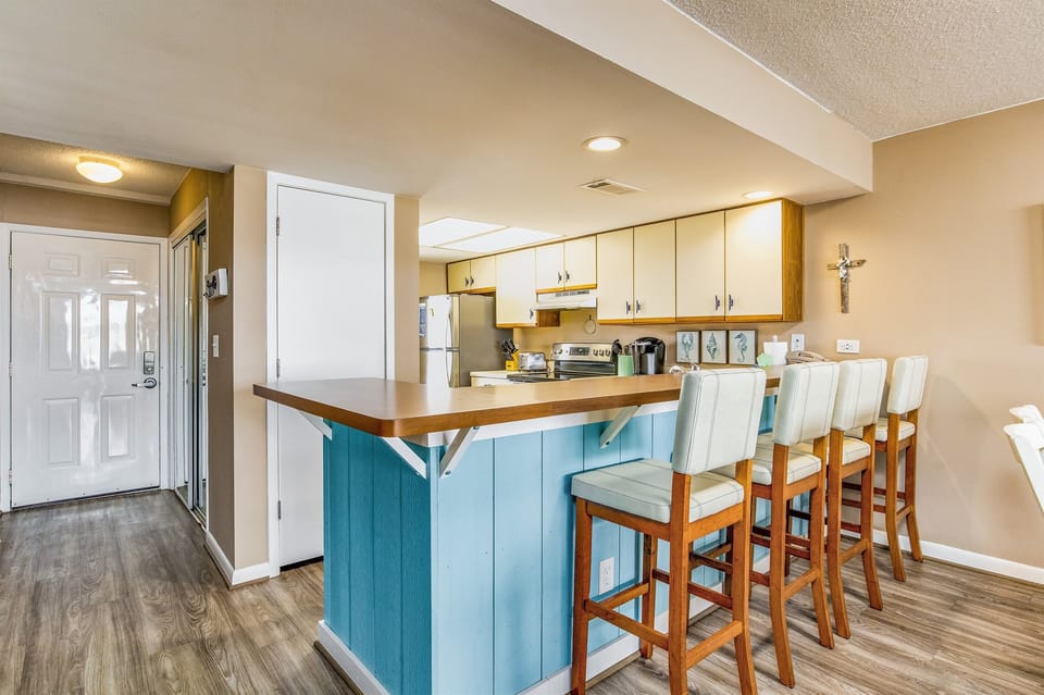 Fully equipped kitchen with stainless appliances and tile countertops with breakfast bar for 4 at Wind Drift Orange Beach waterfront vacation rental
