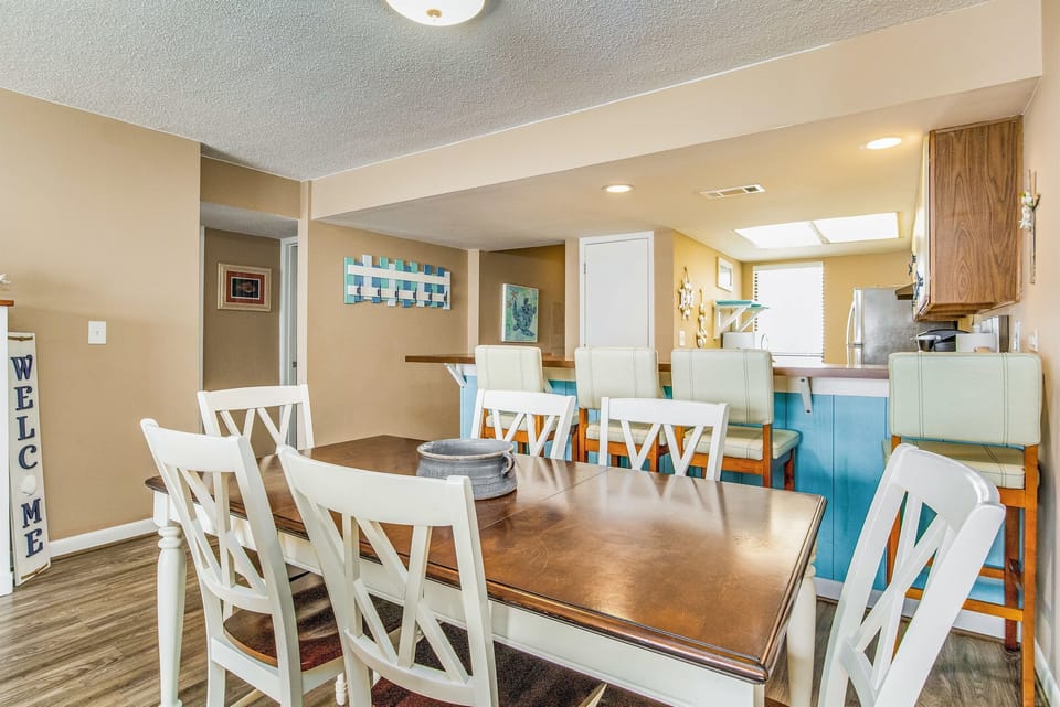 Open-concept dining with comfortable seating for 6 and stunning Old River views at Wind Drift Orange Beach bayfront condo