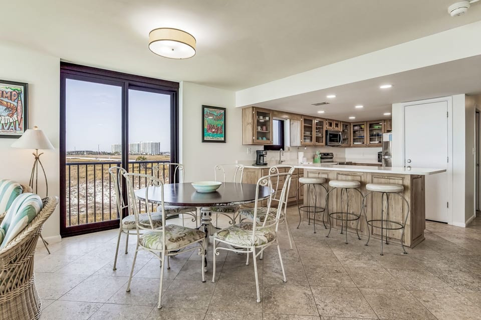 Open living and dining area with floor-to-ceiling Gulf views at Wind Drift 212 SW